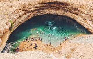 Locals and tourists enjoying a dip at one of Oman's famous sinkholes
