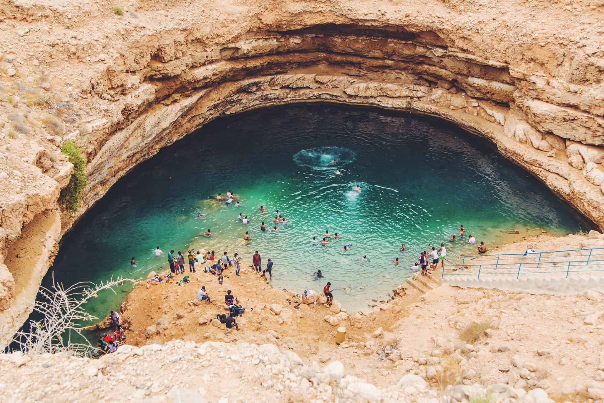 Locals and tourists enjoying a dip at one of Oman's famous sinkholes
